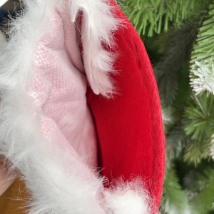 Close-up of red Christmas stocking opening with plush white faux fur trim on a tree
