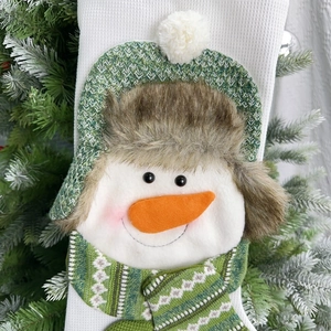 Close-up of a large white waffle fabric Christmas stocking with a 3D snowman character detail