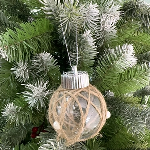 Dettaglio pallina di Natale trasparente con rete in corda di iuta e perle bianche