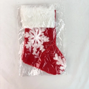 Close-up of red knit Christmas stocking with white snowflake pattern in clear packaging