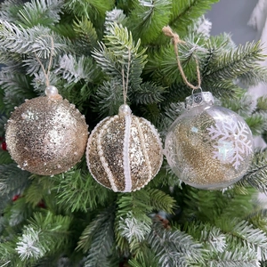 Set of 8cm gold Christmas balls with glitter and pearls hanging on a green Xmas tree branch