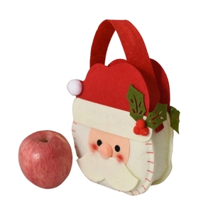 Felt Christmas Santa candy bag with red handle and holly leaf detail next to a red apple