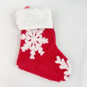Detail of red Christmas stocking with white snowflake embroidery and plush faux fur trim