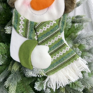 Detailed close-up of a snowman Christmas stocking featuring knitted scarf and felt textures
