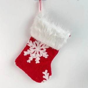 Close-up of red plush Christmas stocking with white snowflake and faux fur cuff