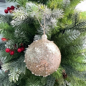 Close-up of 8cm champagne gold glitter Christmas ball with beads and pearl detail on a tree