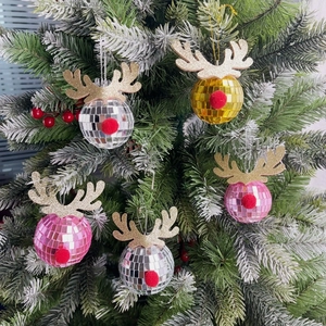 Close-up of disco mirror ball reindeer ornaments hanging on a frosted Christmas tree branch