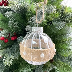 Detail of 8cm champagne Christmas ball with burlap ribbon and pearls on pine branch