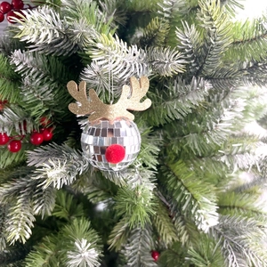 Close-up of reindeer disco ball ornament with golden antlers on a Christmas tree branch