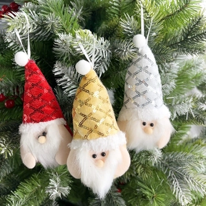 Three sequined Christmas gnomes with long white beards hanging on a green Xmas tree