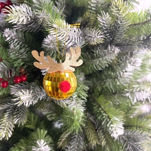 Close-up of golden disco mirror ball ornament with reindeer antlers and red nose on a tree