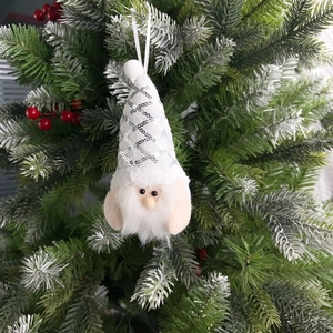 Detail of sequined Christmas gnome ornament with white beard on a festive tree