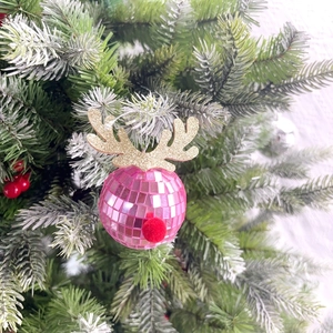 Pink mirrored disco ball reindeer ornament with golden antlers on a Christmas tree