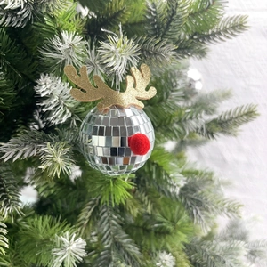 Close-up of disco mirror ball with golden glitter reindeer antlers on a Christmas tree