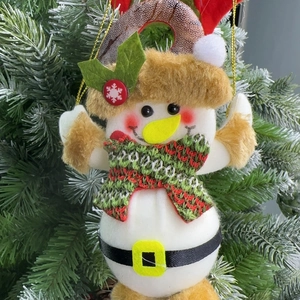 Detail of Christmas snowman ornament with green scarf hanging on a festive Xmas tree