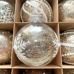 Detail of 8cm gold Christmas ornaments with snowflake patterns and pearl accents in a box