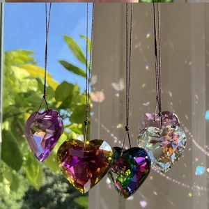 Macro view of multifaceted crystal heart pendants with rainbow light refraction