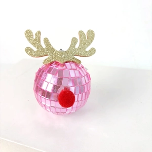 Macro detail of a pink disco ball Christmas ornament with gold sequin antlers and a red nose