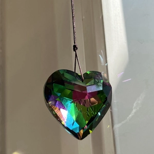 Multifaceted crystal heart pendant with iridescent color reflections and hanging cord