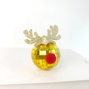 Detail of golden mirror disco ball Christmas ornament with glittery reindeer antlers