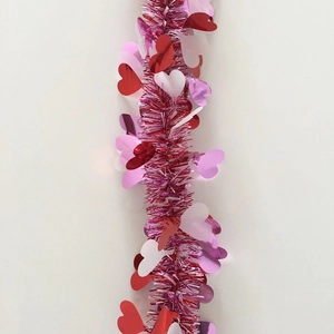 Close-up of pink festive tinsel garland with red and white heart sequins for party decor