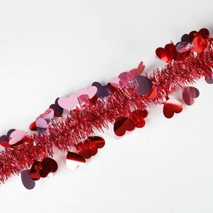 Detail of red tinsel garland featuring shiny metallic hearts for Valentine party decor