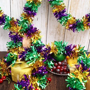 Close-up of Mardi Gras tinsel garland in green, purple and gold on a holiday table