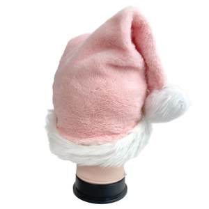 Detailaufnahme des rosa Plüsch-Weihnachtshuts mit weichem weißem Rand und flauschigem Bommel