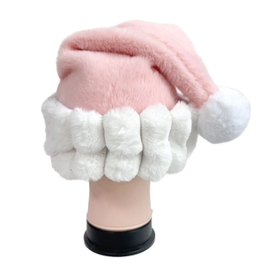 Close-up of pink plush Christmas hat featuring thick white faux fur trim and pom-pom detail