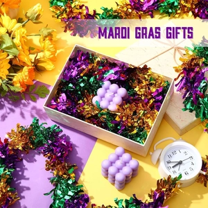Detail of purple bubble candles and Mardi Gras gift box with festive shredded paper decor