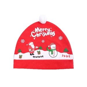 Detail of red plush Santa hat with white pompom and Merry Christmas cartoon prints