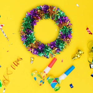 Detail of purple, green, and gold Mardi Gras tinsel garland on a bright festive background
