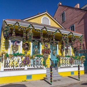 Outdoor setup of Mardi Gras tinsel garlands and wreaths in purple green and gold colors