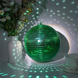 Close-up of green mirror disco ball with reflective tiles for festive party atmosphere