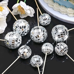Close-up of silver reflective mirror disco ball cake toppers in various sizes for party