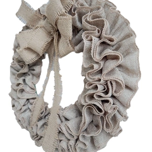 Detail of a handmade rustic burlap wreath featuring tiered ruffled edges and a large bow