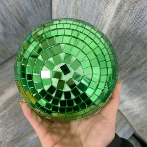 Close-up of green mirror disco ball showing reflective square glass tiles in hand