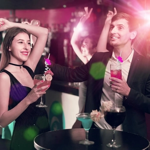 Close-up of disco ball straws with pink cowboy hats in a vibrant party setting