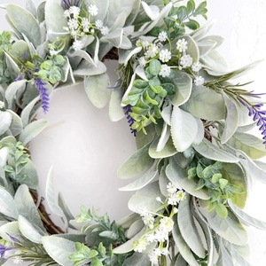 Close-up detail of realistic lavender and baby's breath blossoms on a natural rattan wreath