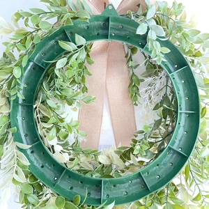 Rear view detail of artificial eucalyptus wreath with durable plastic base and linen ribbon