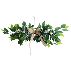Detail of faux greenery garland featuring eucalyptus leaves and a rustic burlap bow decor