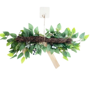 Horizontal wedding arch garland with green leaves and blue berries on rattan base