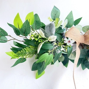 Artificial wedding arch floral swag with greenery, white flowers and burlap bow decor