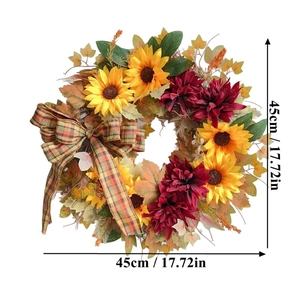 Artificial autumn wreath with sunflowers, maple leaves, and a checkered bow on white background