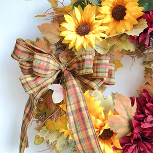 Fall wreath with sunflowers dahlia flowers maple leaves and a large plaid bow decoration