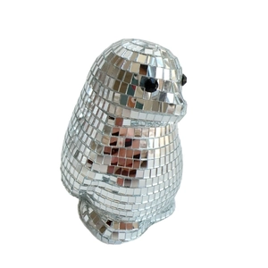 Detailed macro view of penguin disco ball decor with silver mirrored mosaic glass tiles