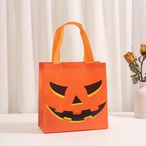 Detail of reinforced orange non-woven Halloween gift bag with a pumpkin face design