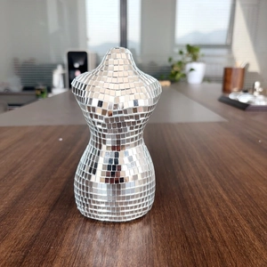 Détail de mosaïque de miroir disco sur une sculpture de torse féminin décorative