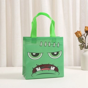 Detail of green non-woven Halloween gift bag with Frankenstein monster face print