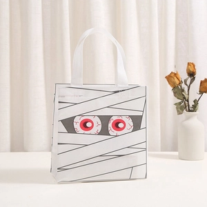 Detailed view of white Halloween mummy non-woven gift bag with scary red eye prints